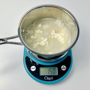 Water and flour inside the saucepan sitting on top of the scale.